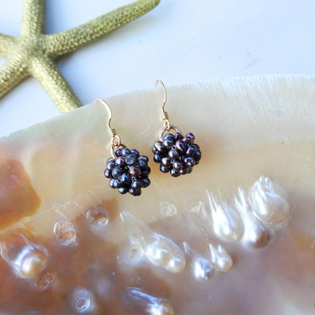 Grijze zoetwater Parel oorhangers in bol vorm.