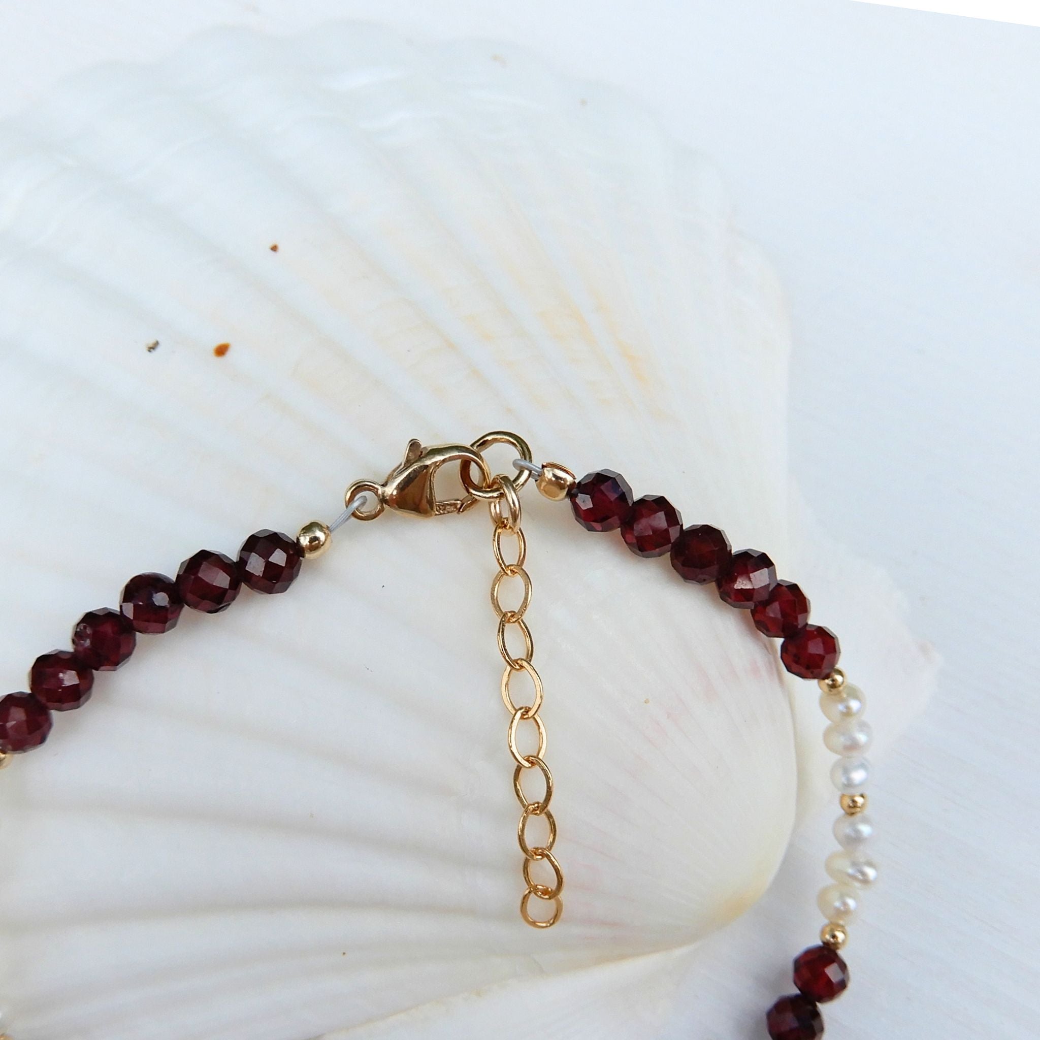 Granaat facet armband in combinatie met zoetwater Parel en goudkleurig slot met verlengketting.