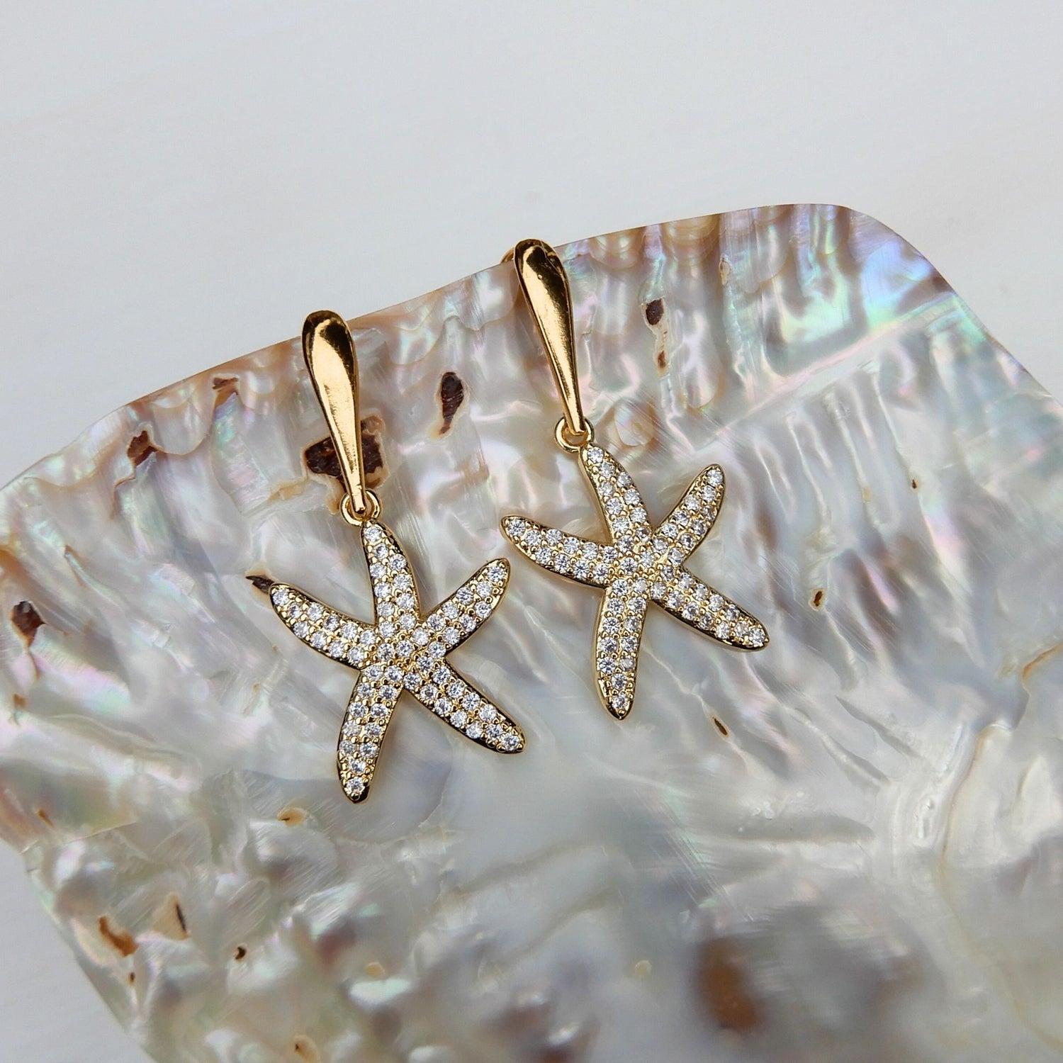 Prachtige oorhangers met zirkonia zeester bedel en goudkleurige haken.