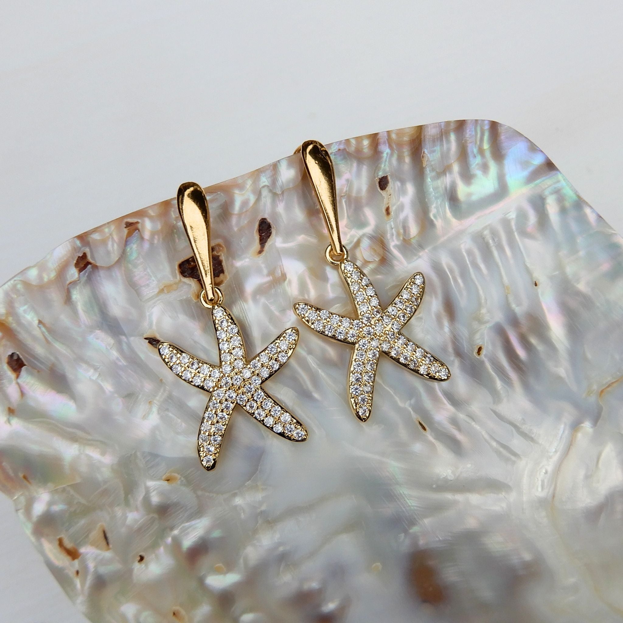 Prachtige oorhangers met zirkonia zeester bedel en goudkleurige haken.