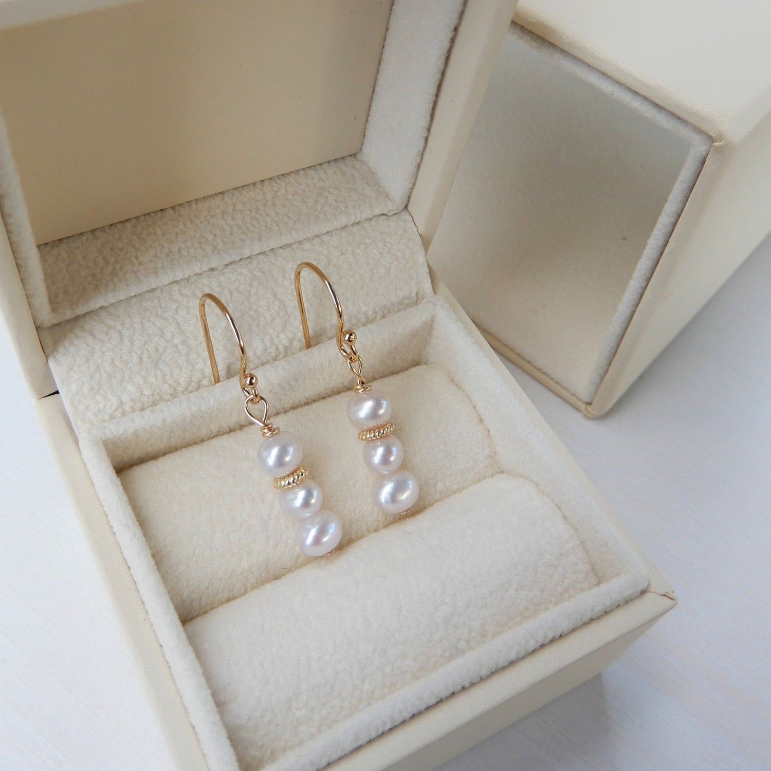 Zoetwater Parel oorhangers in combinatie met bewerkte goudkleurige rondel.