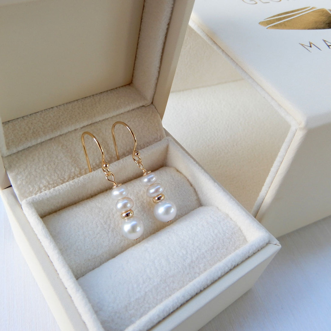 Zoetwater Parel oorhangers oplopend met goudkleurige rondel.