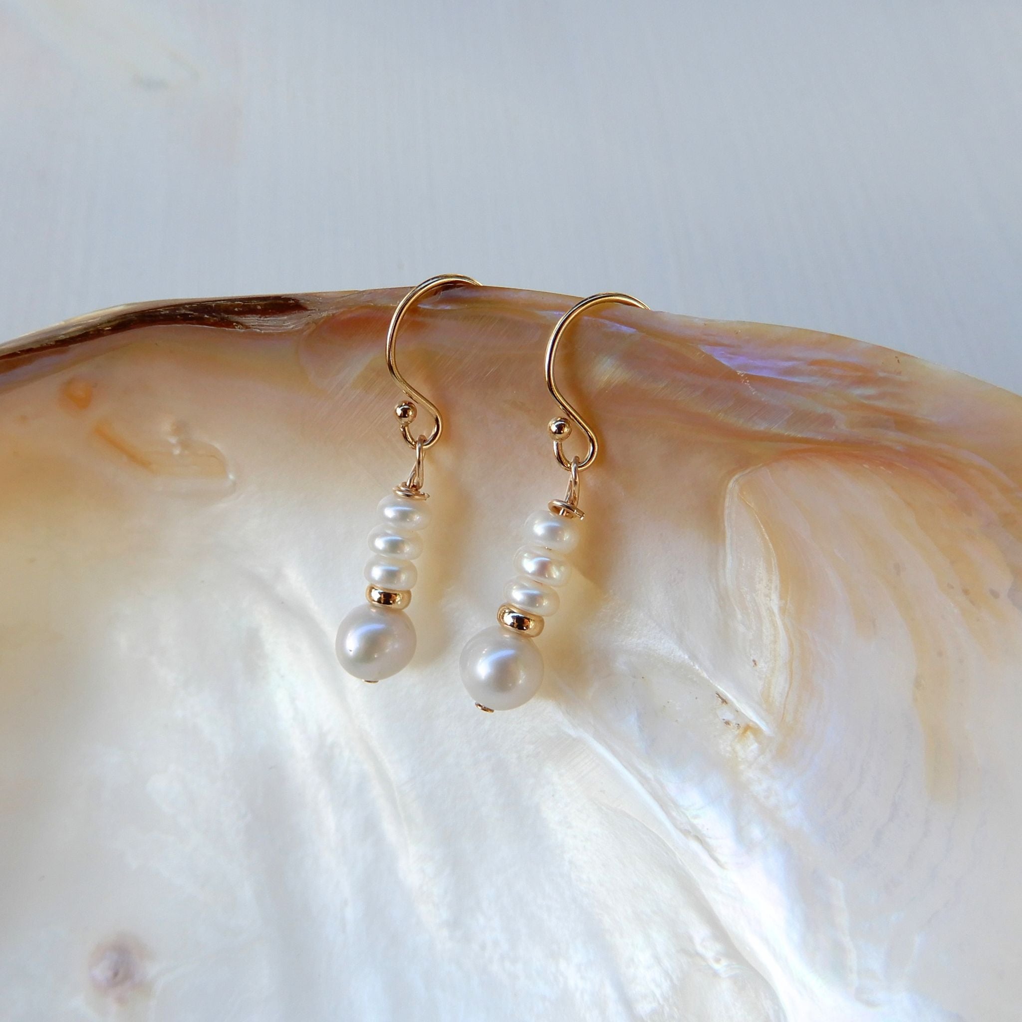 Zoetwater Parel oorhangers in oplopend model met goudkleurige rondel tussenkraal.